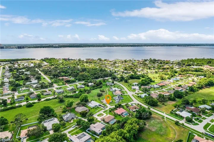 Aerial view of property and surrounding area featuring a large body of water and nearby suburban area