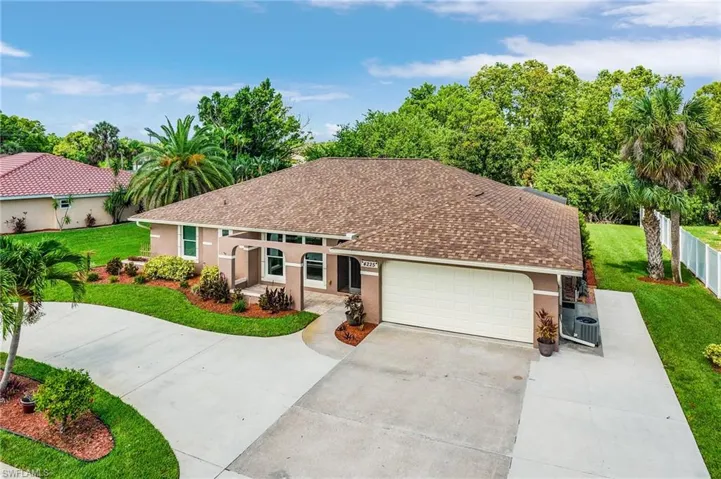 View of front facade featuring stucco siding, concrete driveway, a garage, and a shingled roof