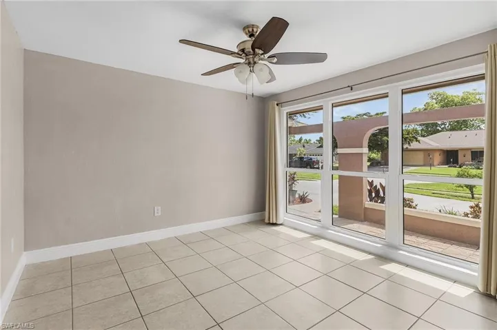 Unfurnished room with light tile patterned floors and ceiling fan