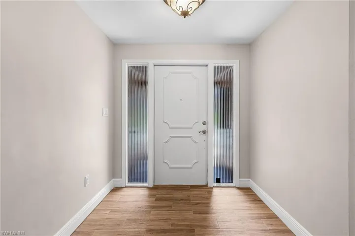 Foyer with wood finished floors and baseboards