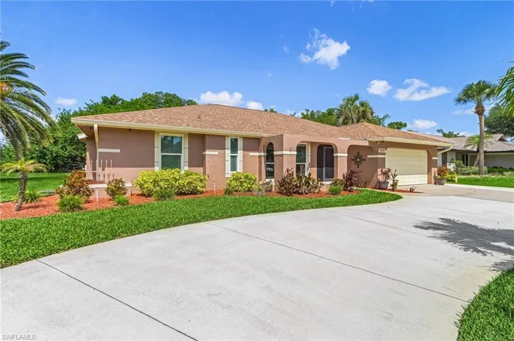 Single story home featuring a garage, stucco siding, driveway, and a front yard
