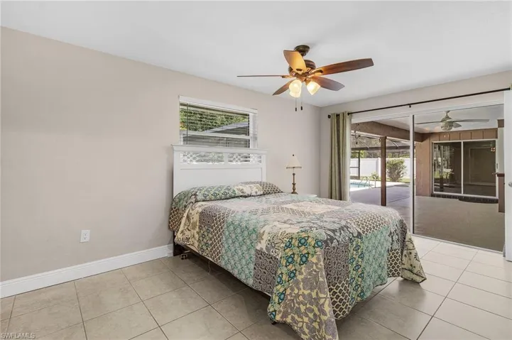 Bedroom featuring access to exterior, multiple windows, tile patterned flooring, and ceiling fan
