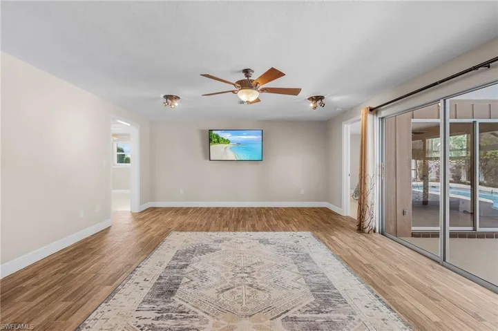 Unfurnished room with wood finished floors, plenty of natural light, and a ceiling fan