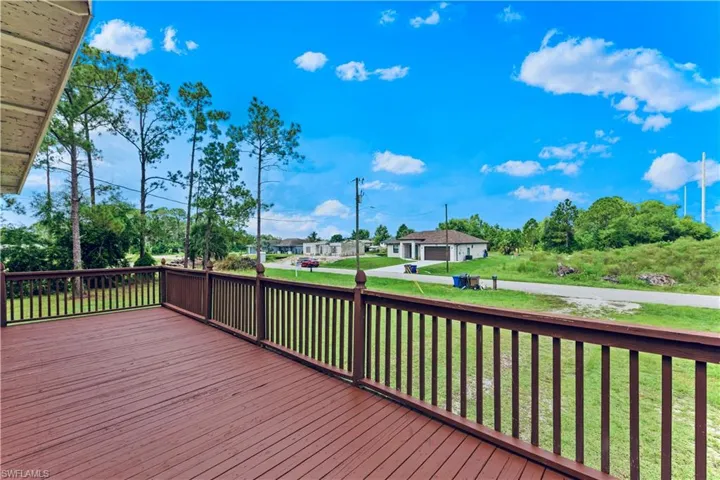 Wooden deck featuring a yard and a garage