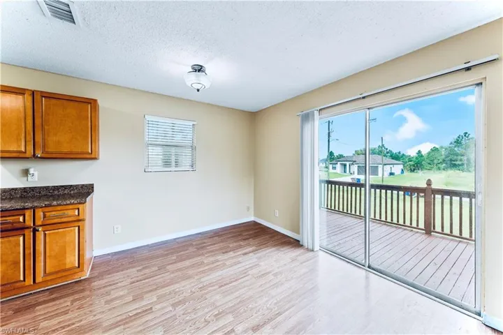 Unfurnished dining area with a wealth of natural light, a textured ceiling, and light hardwood / wood-style flooring