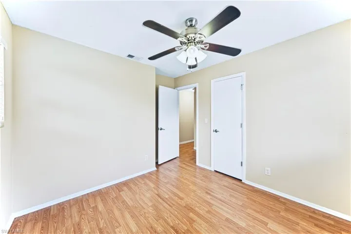 Unfurnished bedroom with ceiling fan and light wood-type flooring