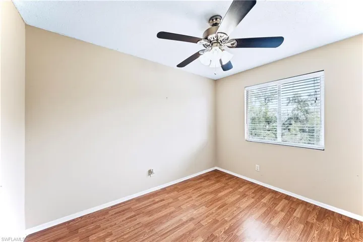Unfurnished room with hardwood / wood-style floors, ceiling fan, and a textured ceiling