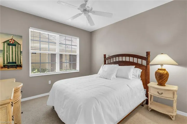 Bedroom with light colored carpet and a ceiling fan