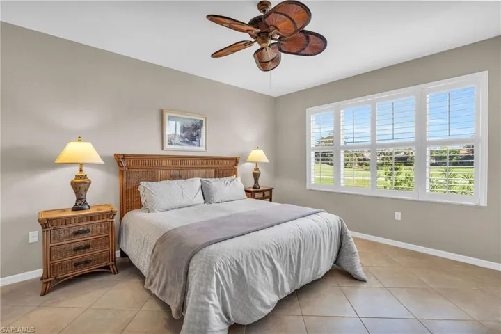 Bedroom with light tile patterned floors and ceiling fan