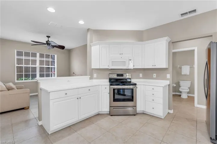 Kitchen featuring stainless steel appliances, open floor plan, recessed lighting, a peninsula, and light countertops