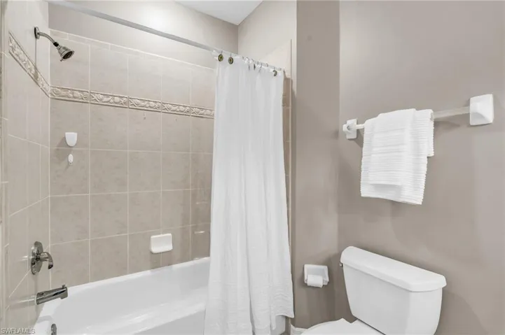 Full bath with toilet and shower / bath combo with shower curtain