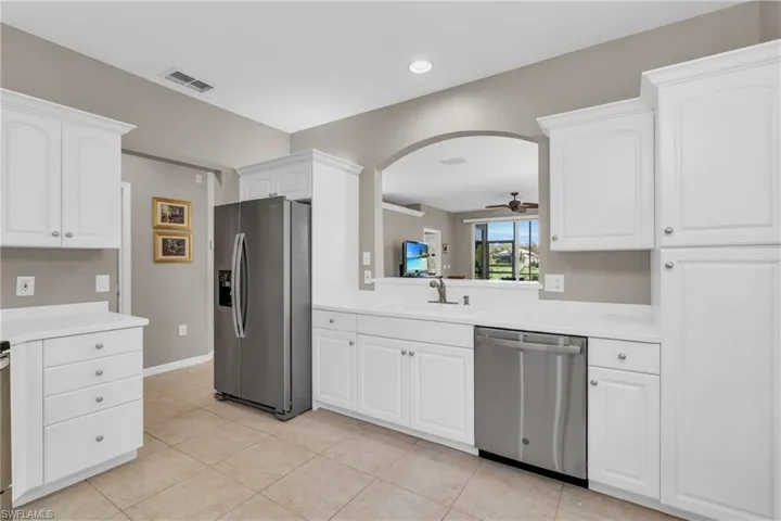 Kitchen featuring appliances with stainless steel finishes, ceiling fan, light countertops, white cabinets, and recessed lighting