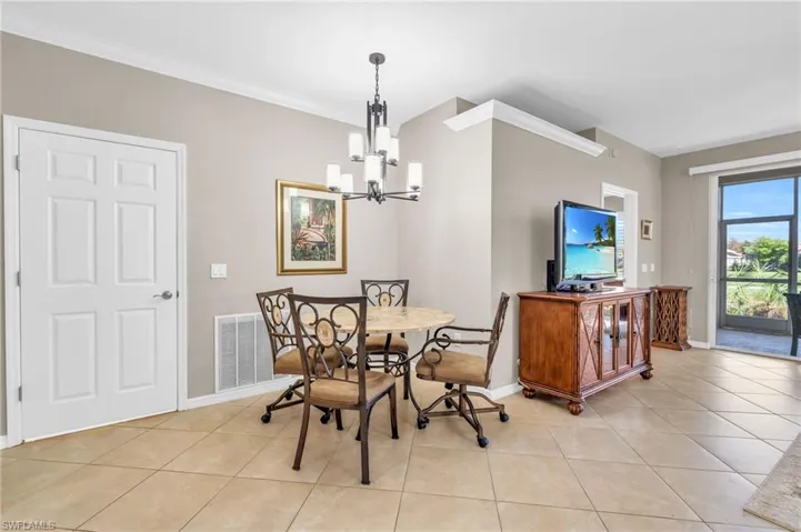 Dining space featuring a chandelier, light tile patterned floors, and ornamental molding
