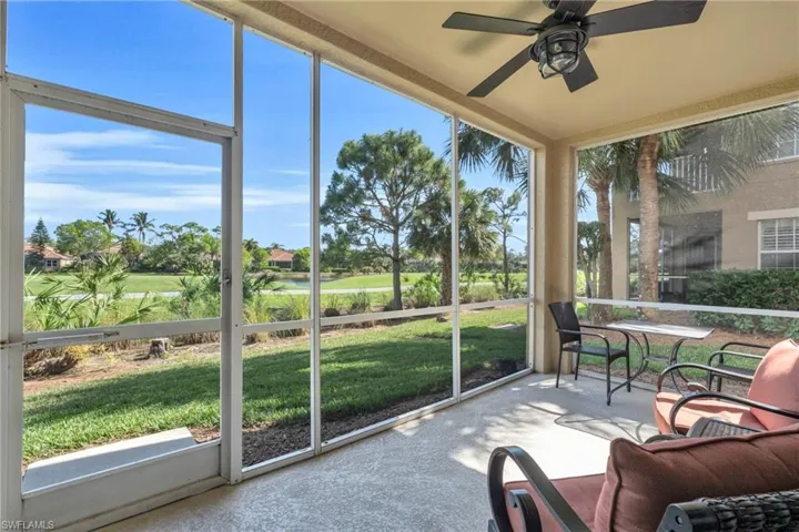 Sunroom / solarium featuring view of golf course and a ceiling fan