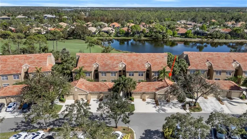 Aerial view of residential area featuring a nearby body of water and a golf course