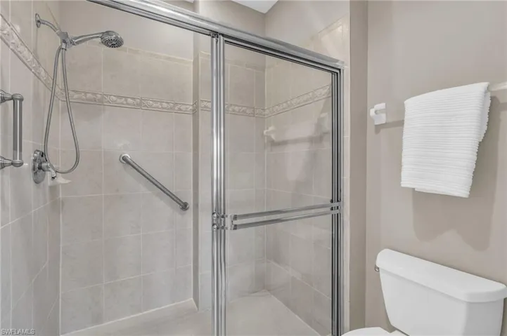 Full bath featuring toilet and a shower stall