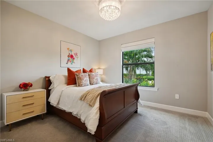 Carpeted bedroom with a notable chandelier