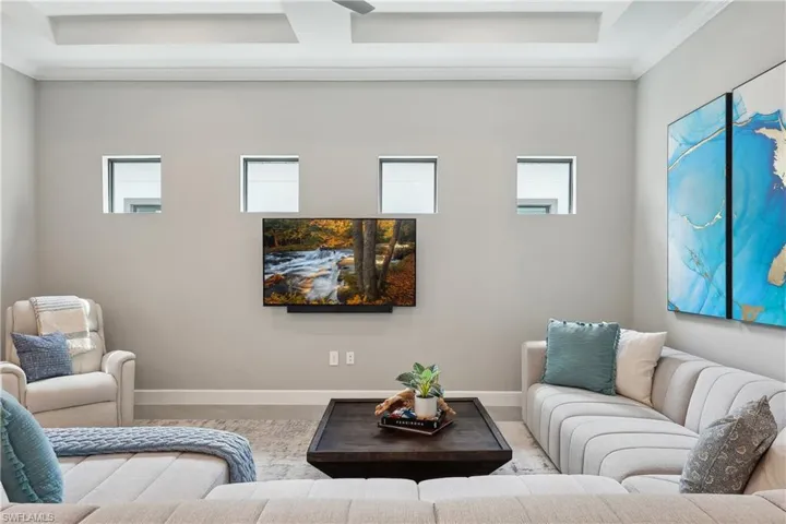 Living room with crown molding and a wealth of natural light