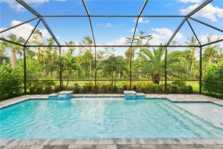 View of swimming pool with a lanai and pool water feature