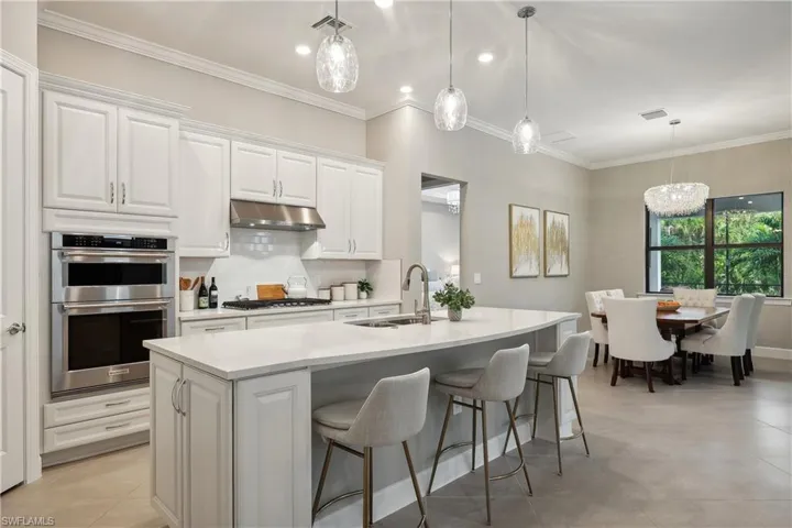 Kitchen featuring a kitchen island with sink, appliances with stainless steel finishes, sink, and white cabinetry