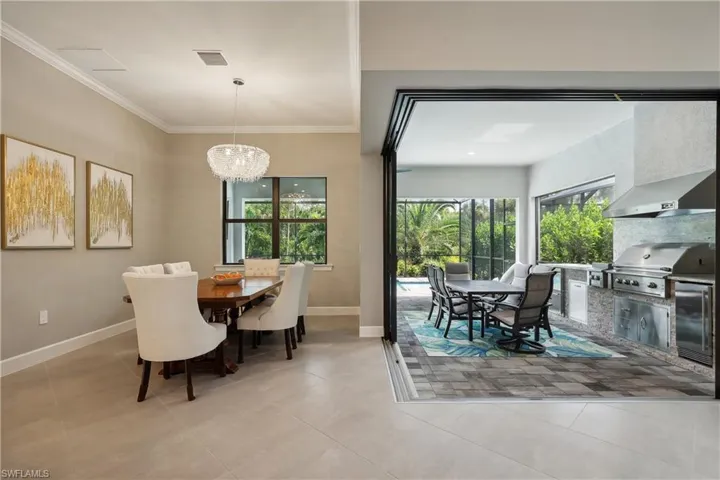 Tiled dining space with an inviting chandelier and crown molding