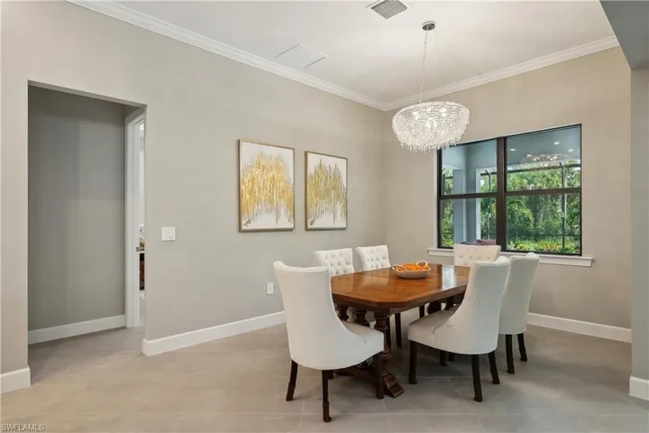 Dining space with ornamental molding and a notable chandelier