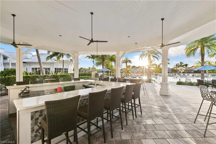 View of patio featuring ceiling fan and a bar