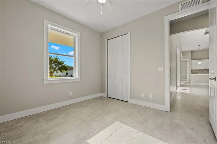 Unfurnished bedroom featuring ceiling fan and light tile patterned flooring
