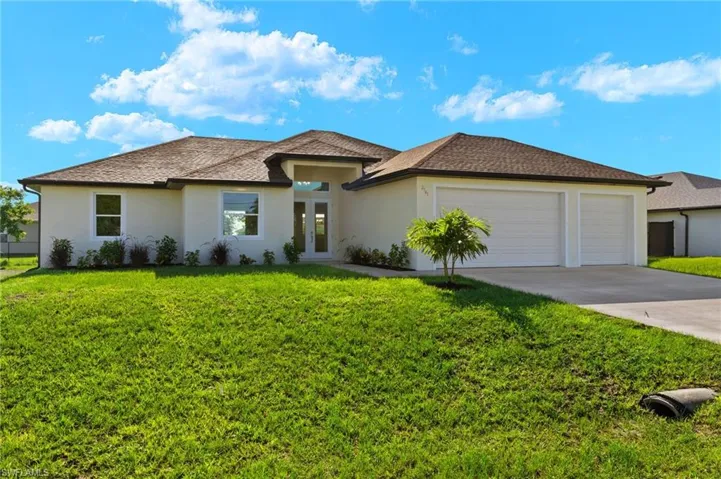 View of front of home with a garage and a front lawn