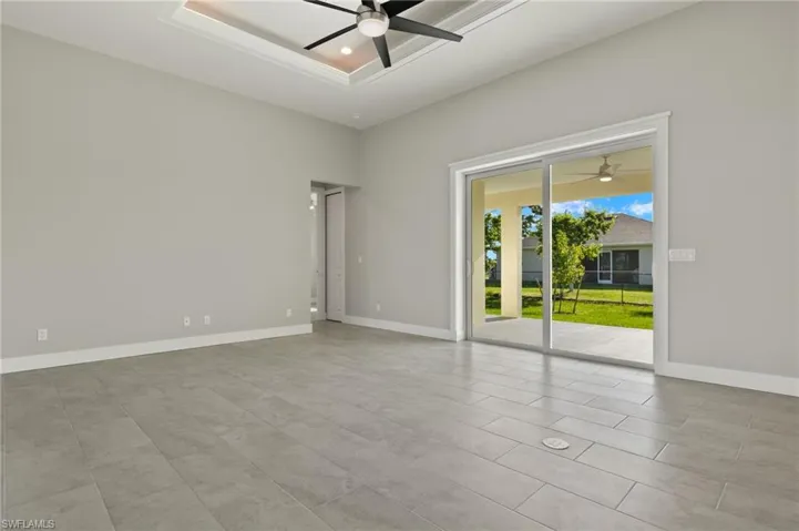 Tiled spare room featuring ceiling fan