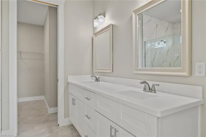 Bathroom featuring tile patterned floors, walk in shower, and vanity