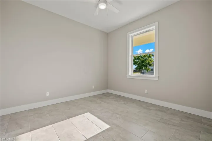Tiled empty room featuring ceiling fan