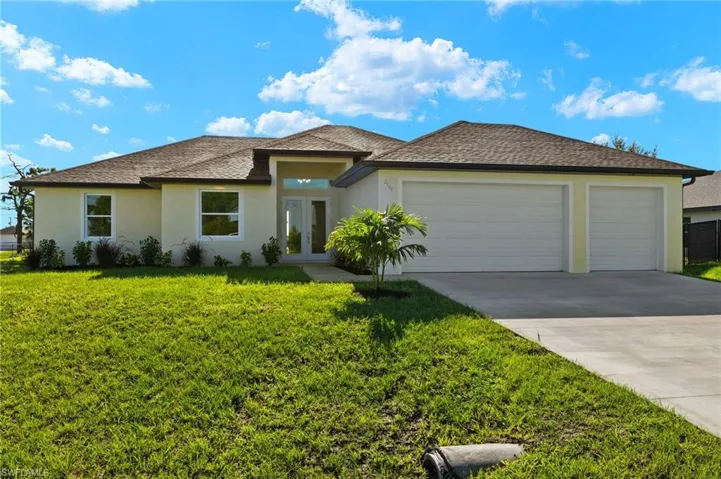 View of front of home with a front yard and a garage