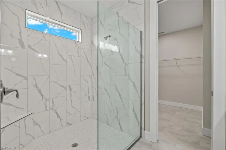 Bathroom with tile patterned flooring and a tile shower
