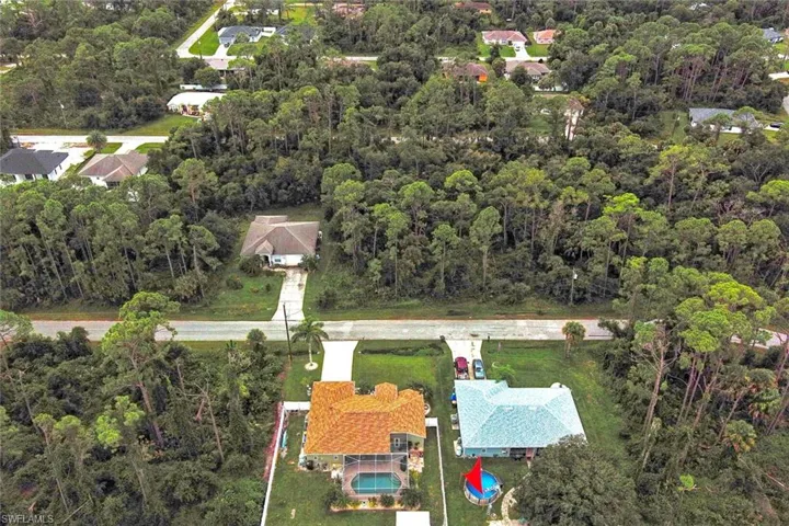View of property location with a heavily wooded area
