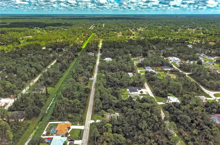 View of property location with a heavily wooded area