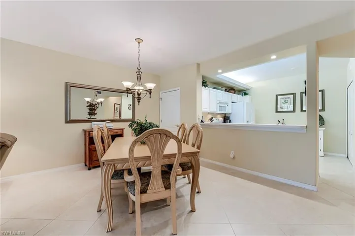 Dining room with light tile patterned flooring, a chandelier, baseboards, and recessed lighting