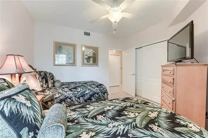 Bedroom with light colored carpet, a closet, and ceiling fan