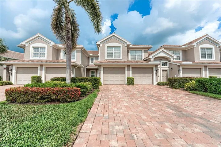Townhome / multi-family property with a garage, decorative driveway, and stucco siding