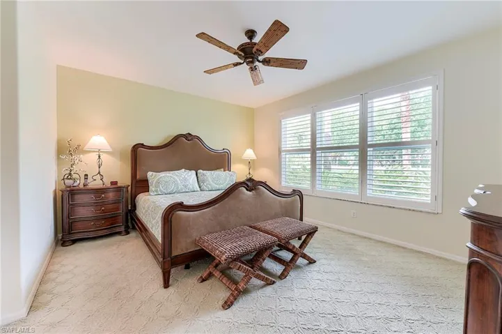 Bedroom featuring baseboards, light carpet, and ceiling fan