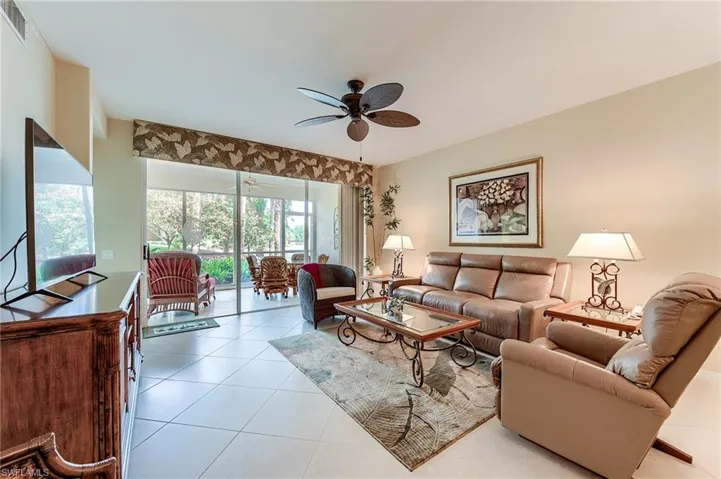 Tiled living room featuring a ceiling fan