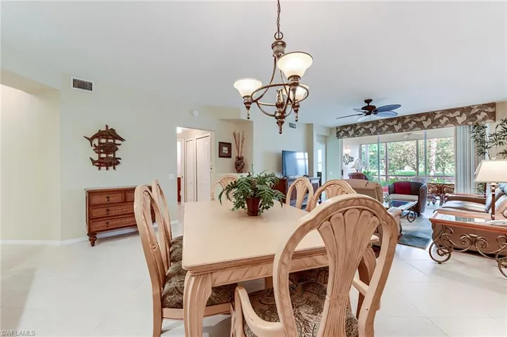 Dining space with a ceiling fan, a chandelier, and light tile patterned floors