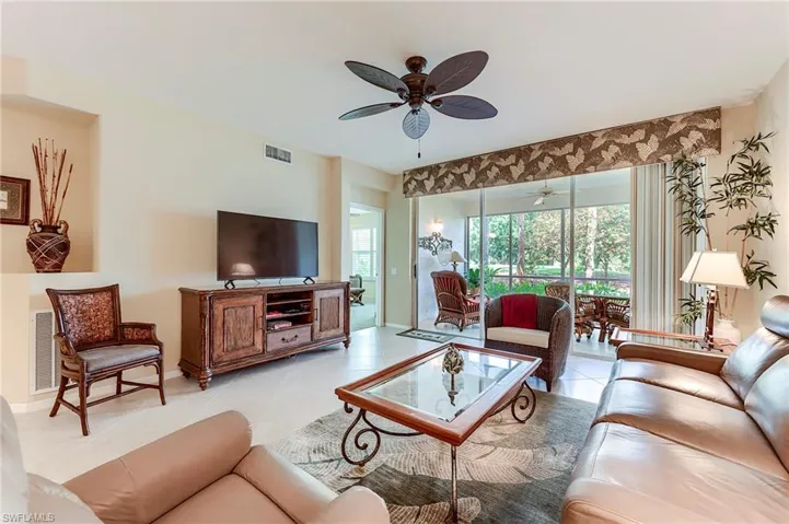 Living area featuring a ceiling fan, light tile patterned floors, and baseboards
