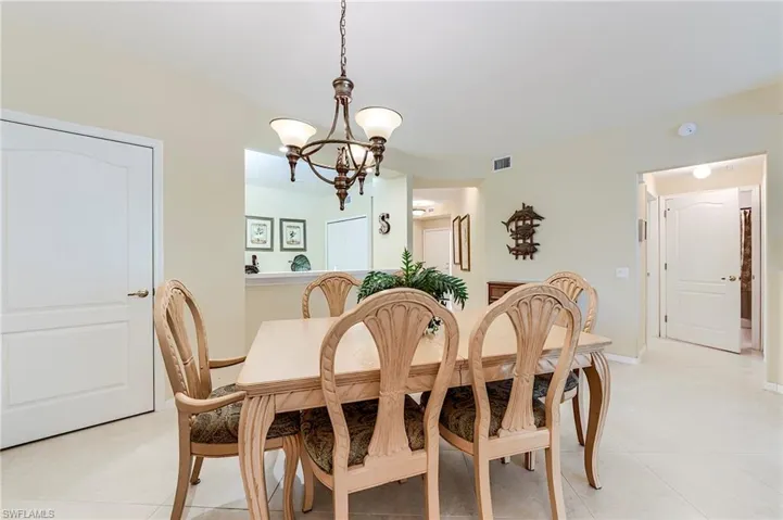 Dining room featuring a chandelier, light tile patterned floors, and baseboards