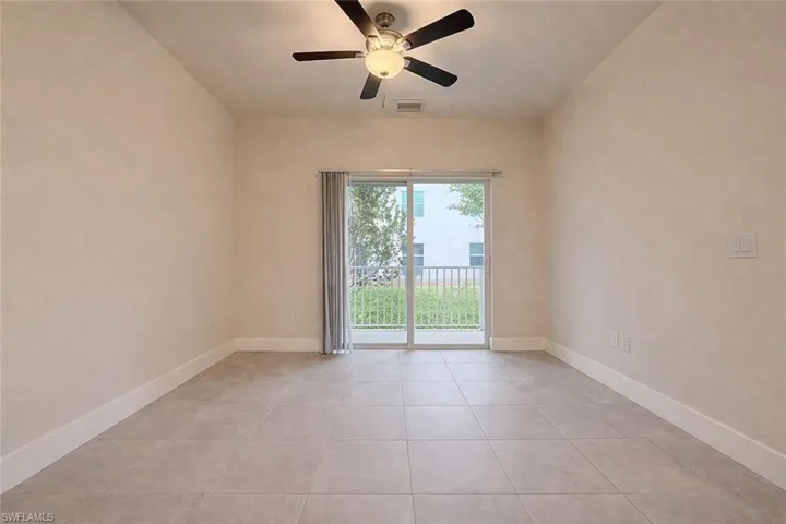 Unfurnished room with ceiling fan and light tile patterned floors