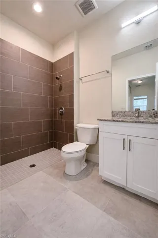 Full bathroom featuring tiled shower and vanity