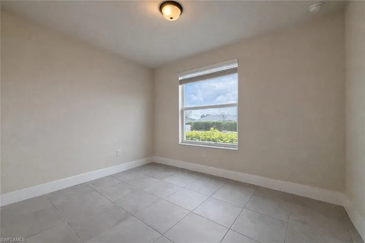 Unfurnished room featuring baseboards and light tile patterned flooring