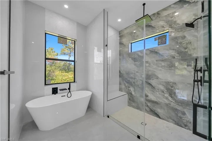 Full bathroom featuring a freestanding tub, a marble finish shower, marble finish floors, and recessed lighting
