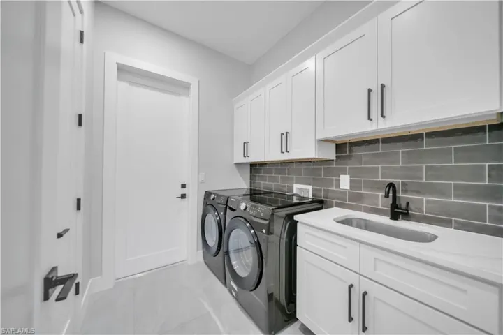 Laundry area with washer and dryer, cabinet space, and baseboards
