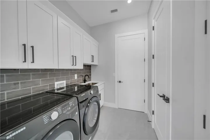 Laundry area with cabinet space, washing machine and clothes dryer, baseboards, and recessed lighting